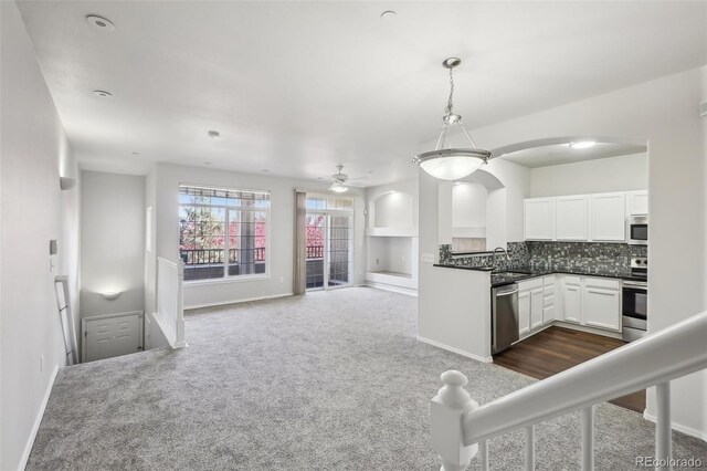 12711 Colorado Blvd Unit 1009, Thornton, CO 80241 - kitchen with appliances with stainless steel finishes, arched walkways, dark carpet, and white cabinets