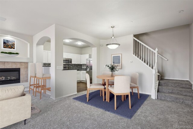 12711 Colorado Blvd Unit 1009, Thornton, CO 80241 - dining room with dark colored carpet, stairway, a tile fireplace, and baseboards