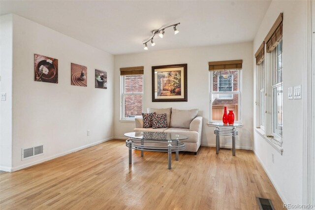 sitting room featuring light wood-style floors, baseboards, and visible vents
