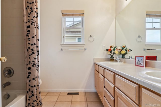 bathroom with visible vents, baseboards, a sink, double vanity, and tile patterned floors