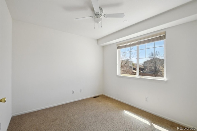 carpeted empty room featuring visible vents, baseboards, and a ceiling fan