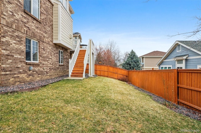 view of yard featuring a fenced backyard and stairway