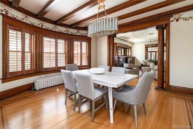dining space with light wood-style floors, radiator, and a healthy amount of sunlight