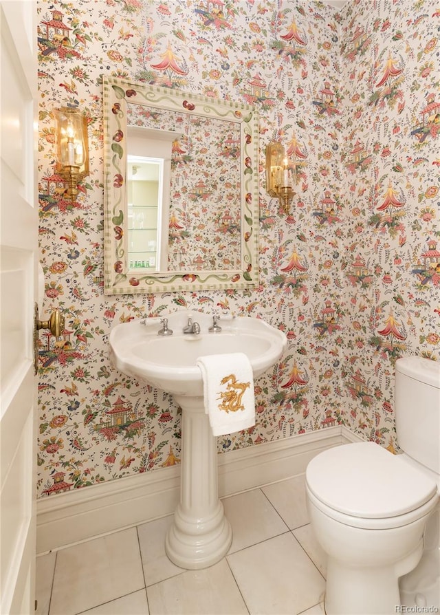 bathroom with toilet, wallpapered walls, and tile patterned flooring