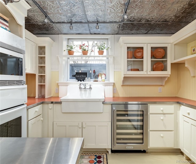bar with oven, a sink, an ornate ceiling, beverage cooler, and built in microwave
