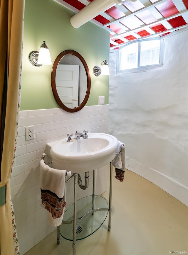 bathroom featuring wainscoting and tile walls