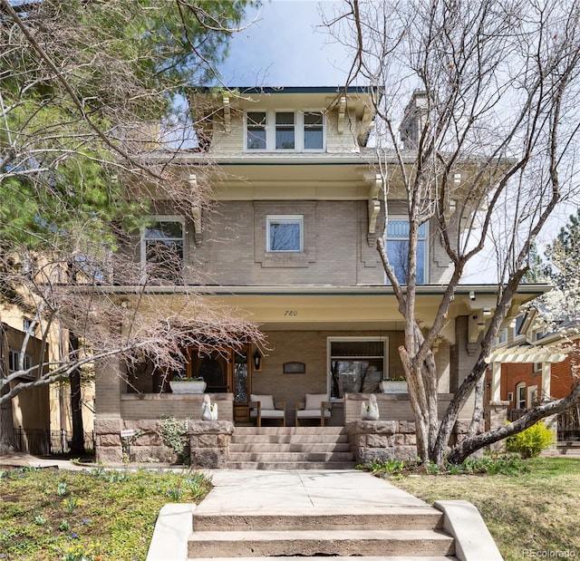 american foursquare style home featuring covered porch