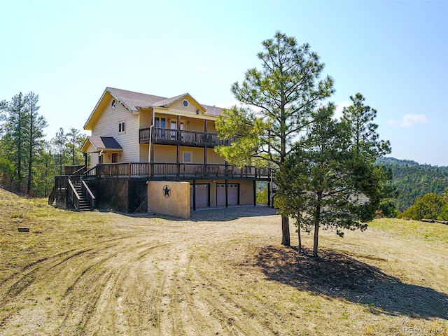 back of house with a garage and a deck