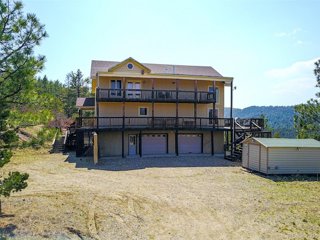 rear view of house with a deck and a garage