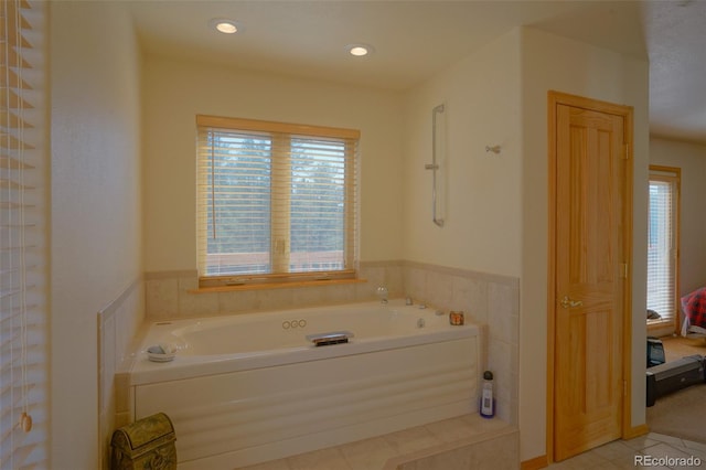 bathroom with a washtub and tile flooring