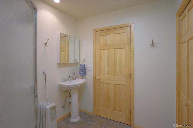 bathroom featuring radiator heating unit and tile floors