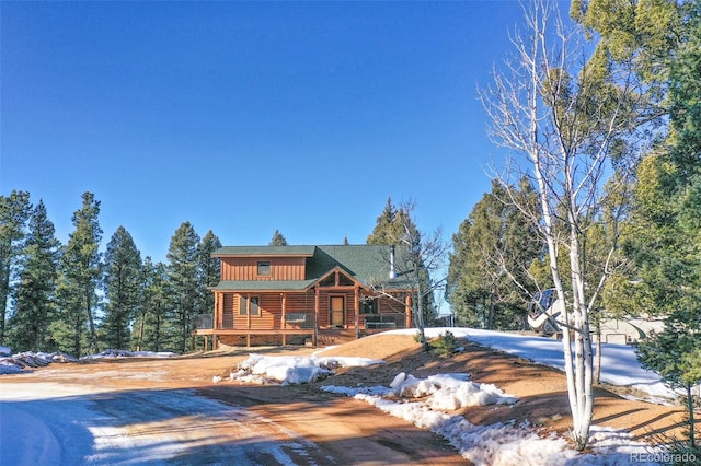 log cabin featuring covered porch