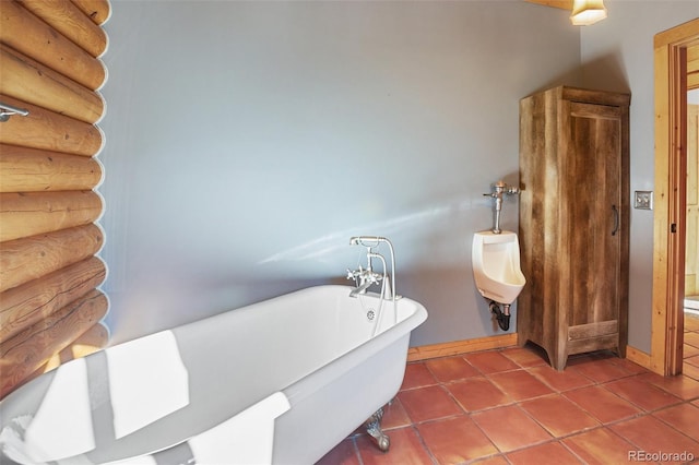 bathroom with a tub to relax in and tile patterned floors