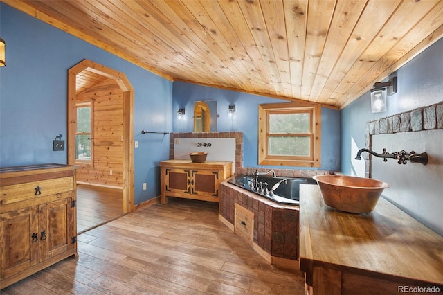 bathroom with wooden ceiling, hardwood / wood-style flooring, vaulted ceiling, and wooden walls