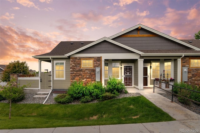 12940 Jasmine St Unit A, Thornton, CO 80602 - view of front of house with french doors, a front yard, and stone siding