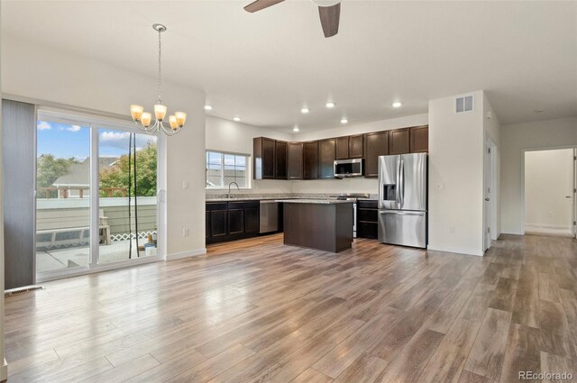 12940 Jasmine St Unit A, Thornton, CO 80602 - kitchen with stainless steel appliances, light wood-type flooring, dark brown cabinets, a chandelier, and recessed lighting
