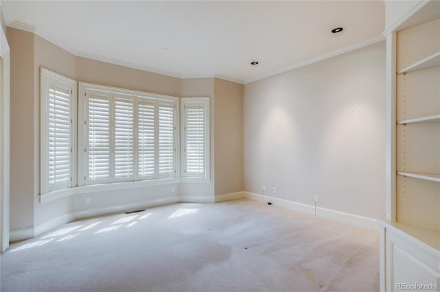 spare room with baseboards, crown molding, carpet flooring, and visible vents