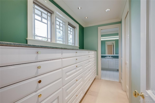 corridor with recessed lighting, light carpet, and a sink