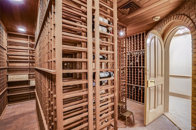 wine area with wood ceiling, brick floor, and recessed lighting