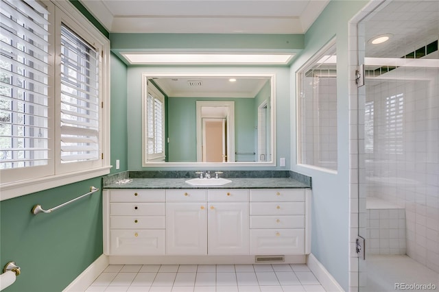 bathroom featuring baseboards, vanity, tile patterned floors, and a stall shower