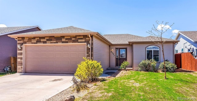 835 Juliana Ct, Canon City, CO 81212 - view of front facade featuring fence, an attached garage, driveway, a front lawn, and a shingled roof