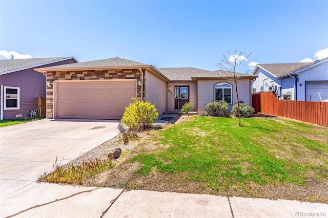 835 Juliana Ct, Canon City, CO 81212 - view of front of house with fence, an attached garage, a front lawn, and concrete driveway