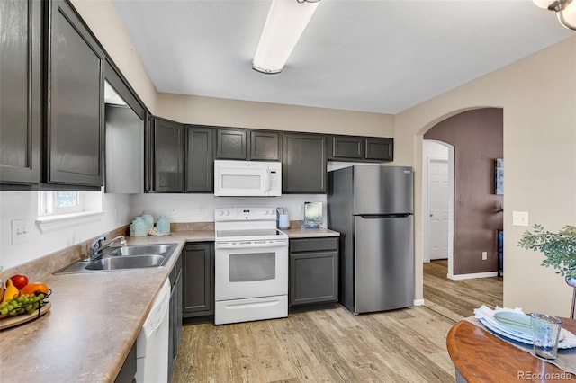 835 Juliana Ct, Canon City, CO 81212 - kitchen with a sink, light wood-type flooring, arched walkways, white appliances, and light countertops