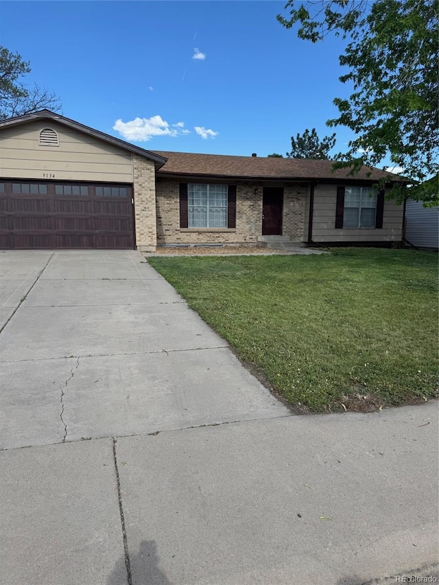 single story home featuring a garage, a front lawn, brick siding, and driveway