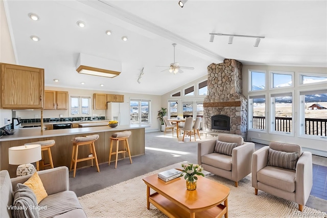 living room featuring a fireplace, lofted ceiling with beams, and ceiling fan