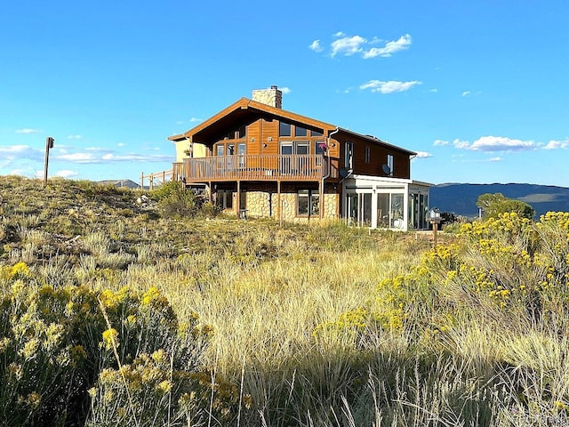 rear view of house with a deck with mountain view