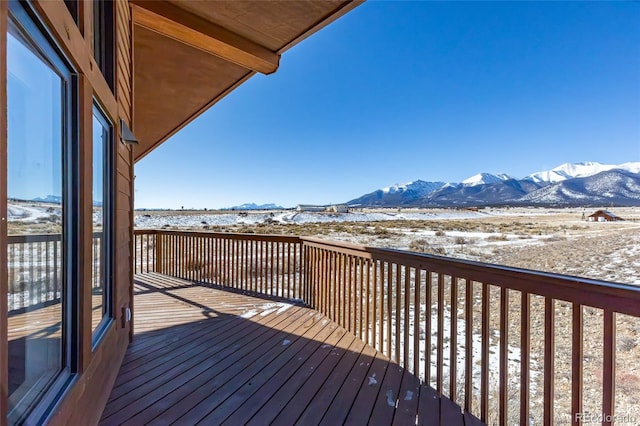 snow covered deck with a mountain view