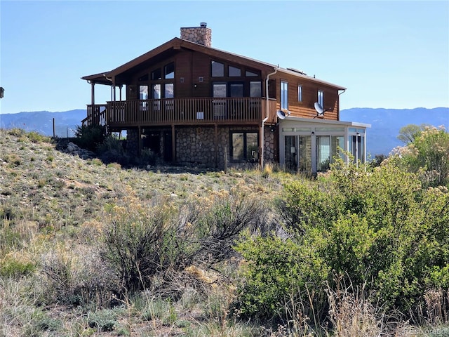 20155 Hideout Ln, Nathrop, CO 81236 - back of property with a chimney, stone siding, and a deck with mountain view