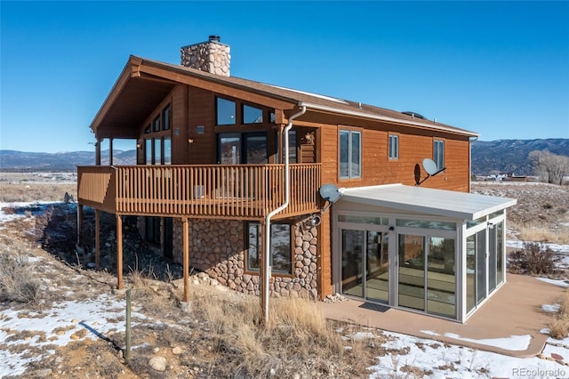 20155 Hideout Ln, Nathrop, CO 81236 - snow covered house featuring a chimney, stone siding, and a deck with mountain view