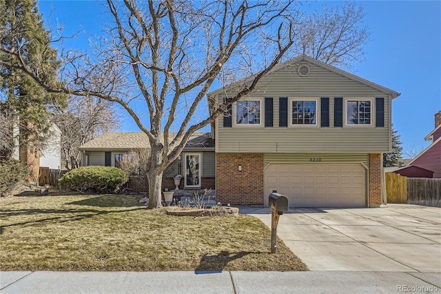 tri-level home featuring a garage, brick siding, fence, concrete driveway, and a front yard