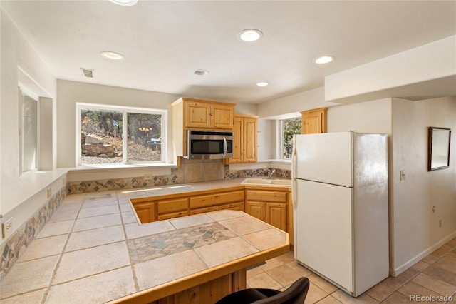249 Valle Escondido Dr, Durango, CO 81303 - kitchen with freestanding refrigerator, light brown cabinets, tile countertops, visible vents, and stainless steel microwave