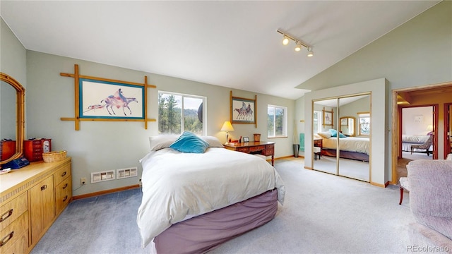 2545 N State Highway 67, Sedalia, CO 80135 - bedroom with light colored carpet, lofted ceiling, track lighting, a closet, and baseboards