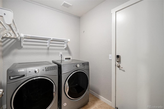washroom with visible vents, baseboards, separate washer and dryer, laundry area, and tile patterned floors