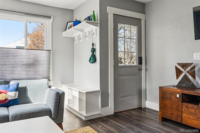 mudroom featuring a textured wall, baseboards, and wood finished floors