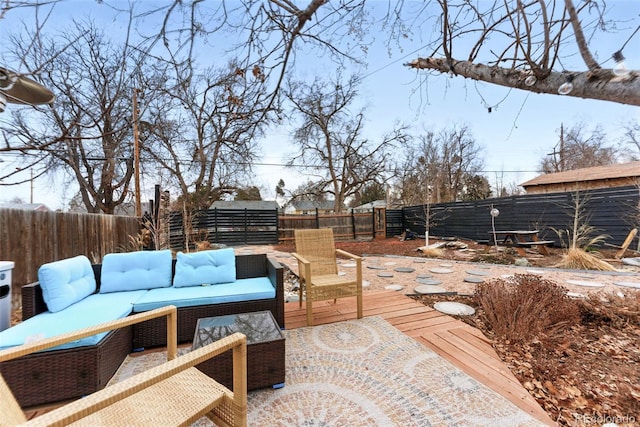 wooden terrace featuring a fenced backyard and an outdoor living space