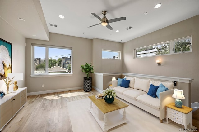 living room with ceiling fan, plenty of natural light, and light hardwood / wood-style flooring