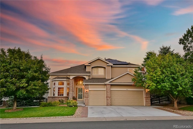 view of front of home featuring a lawn, solar panels, and a garage