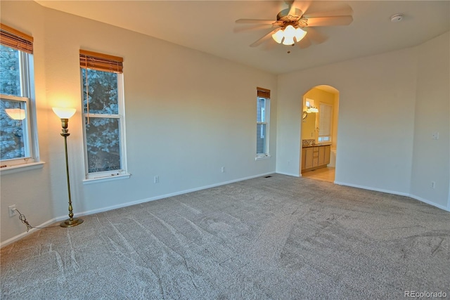 unfurnished room with light colored carpet and ceiling fan