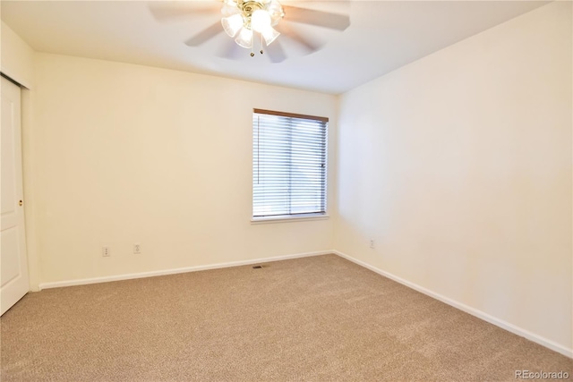 empty room with ceiling fan and light colored carpet