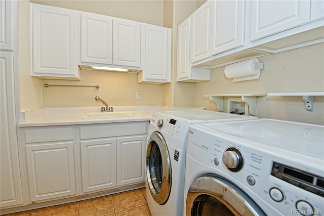 laundry area with sink, light tile patterned floors, cabinets, and independent washer and dryer