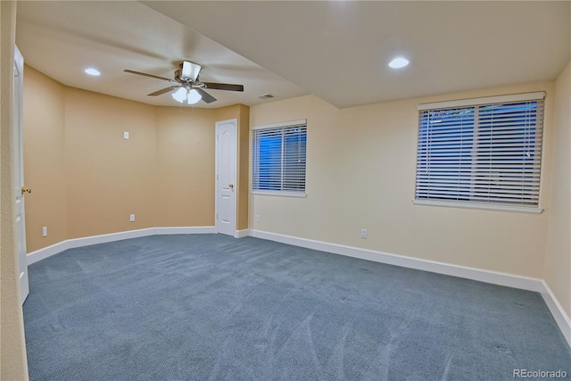 spare room featuring dark carpet and ceiling fan