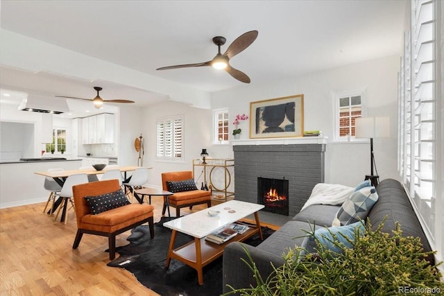 3739 W 46th Ave, Denver, CO 80211 - living room featuring ceiling fan, a brick fireplace, light wood-style floors, and plenty of natural light