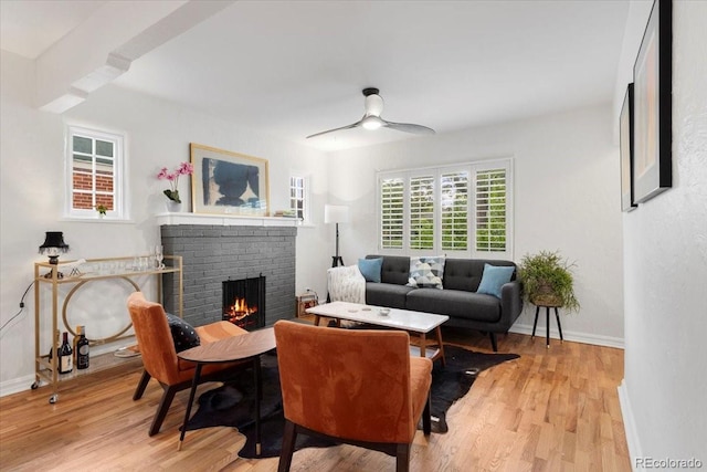 3739 W 46th Ave, Denver, CO 80211 - living room featuring a brick fireplace, light wood-type flooring, ceiling fan, and baseboards