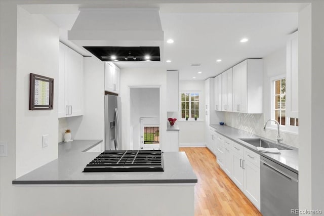 3739 W 46th Ave, Denver, CO 80211 - kitchen featuring stainless steel appliances, a sink, a peninsula, white cabinetry, and recessed lighting