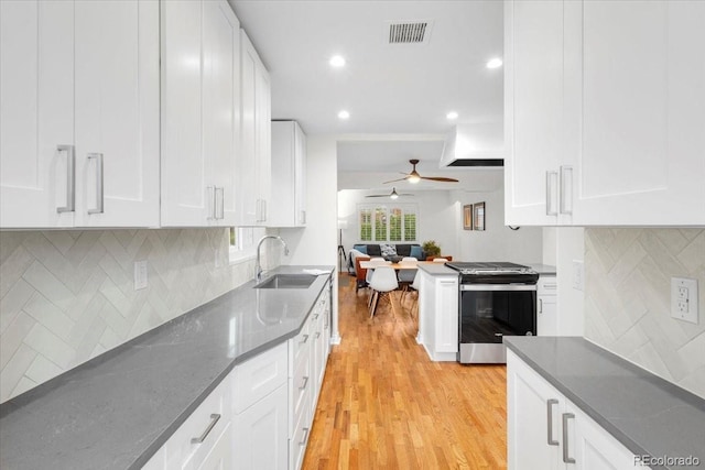 3739 W 46th Ave, Denver, CO 80211 - kitchen featuring gas stove, a sink, light wood-style floors, a ceiling fan, and white cabinetry