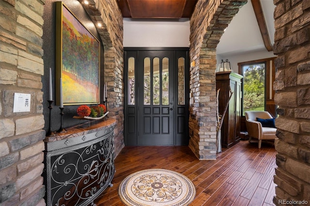 entryway featuring dark wood-style flooring and decorative columns